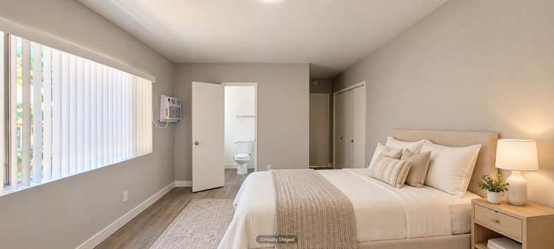 Unit D bedroom toward the bath, virtually staged
