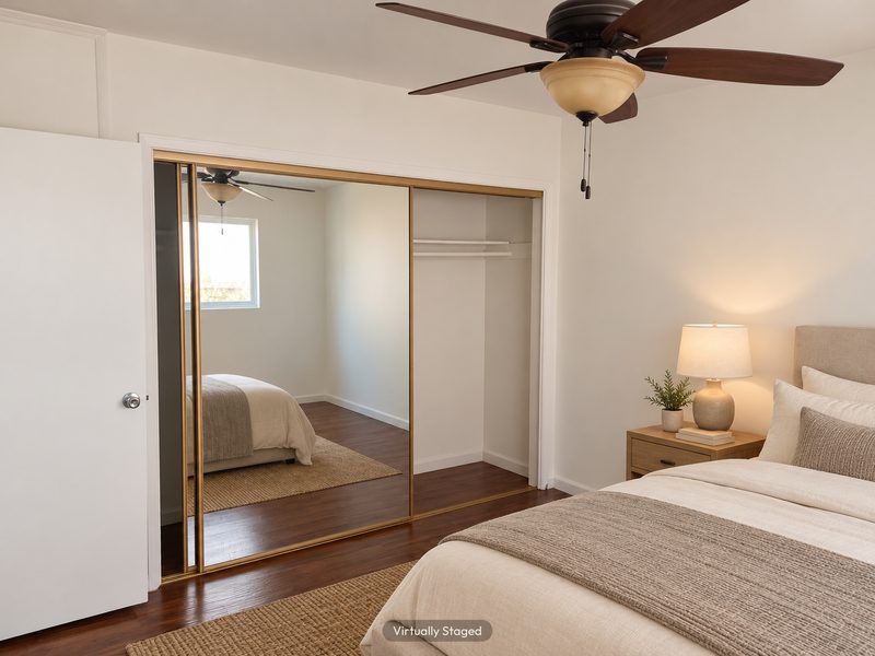Unit E bedroom with mirrored closet doors, virtually staged