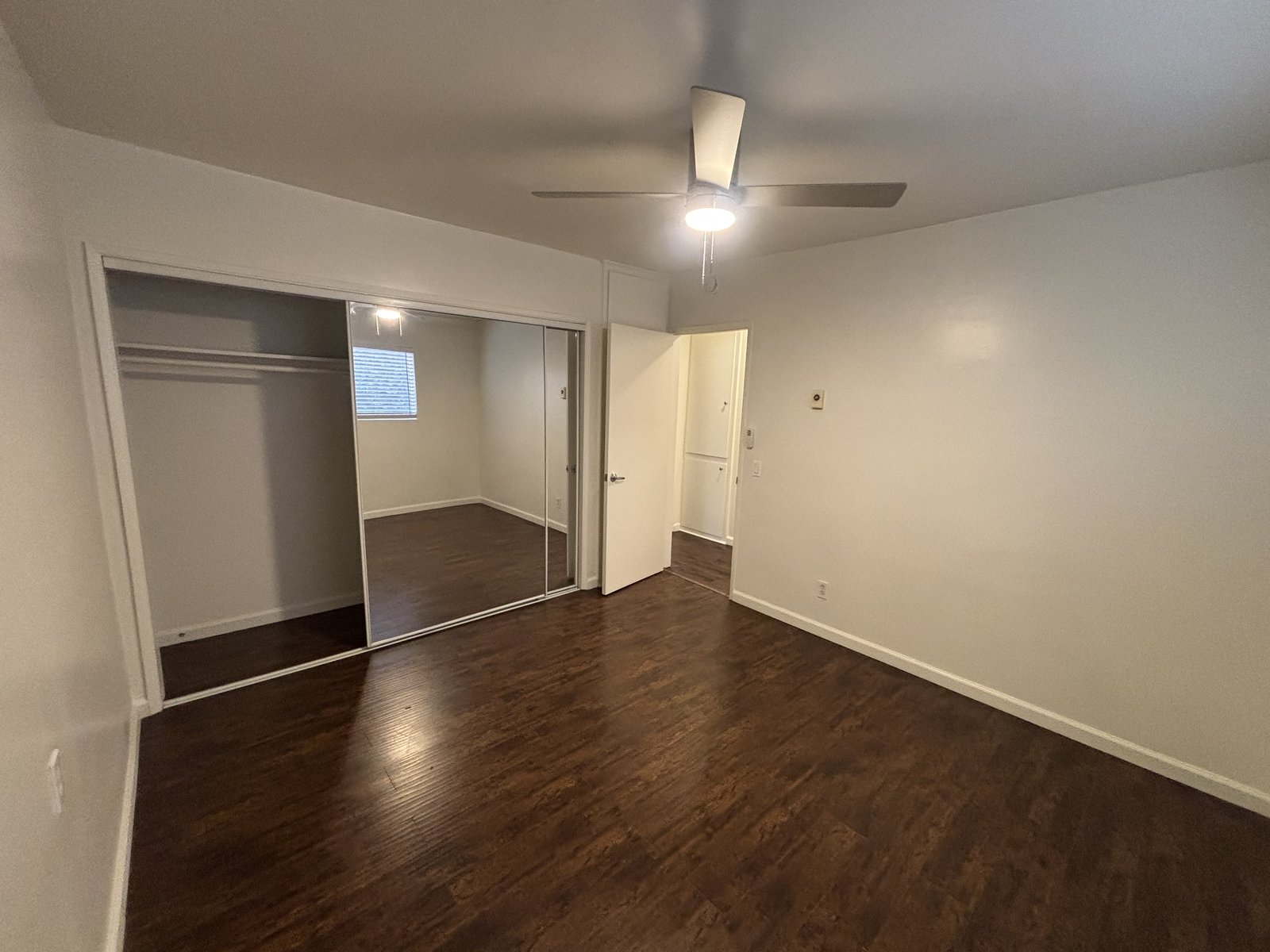 Unit C bedroom with mirrored closet, original unaltered photo