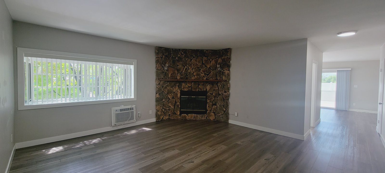 Unit D living room with a stone fireplace, original unaltered photo