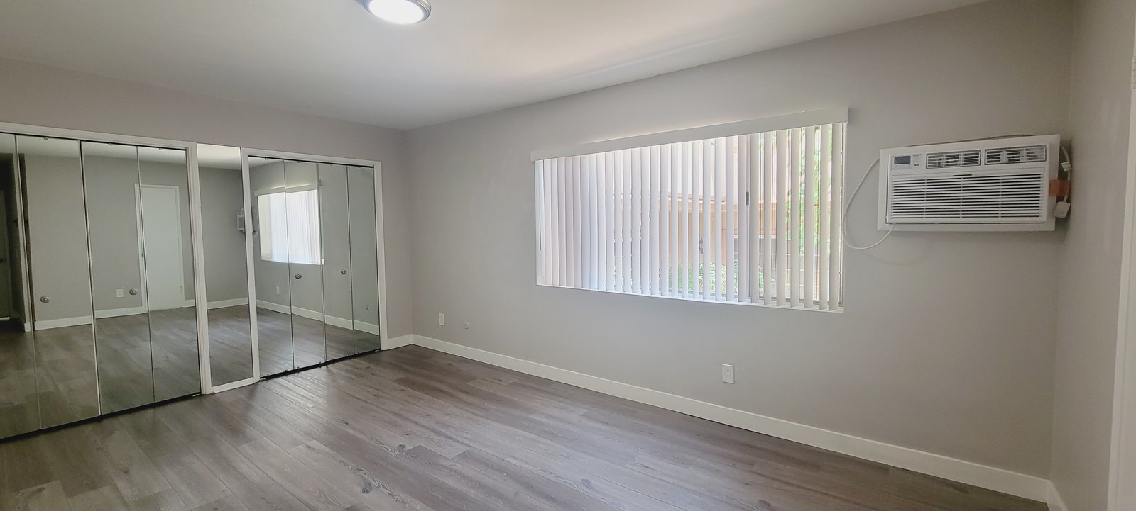 Unit D bedroom with mirrored closet doors, original unaltered photo