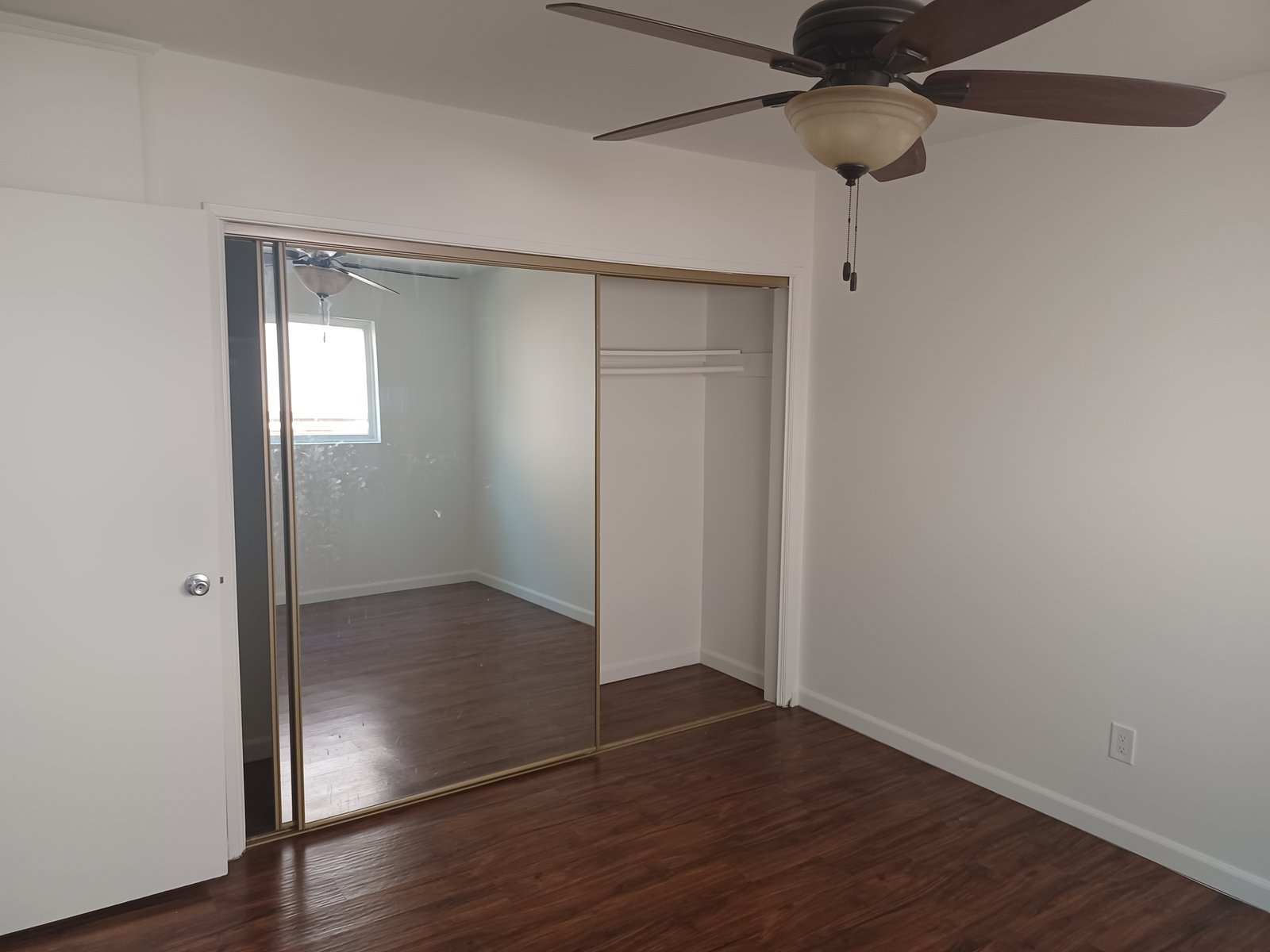 Unit E bedroom with mirrored closet doors, original unaltered photo